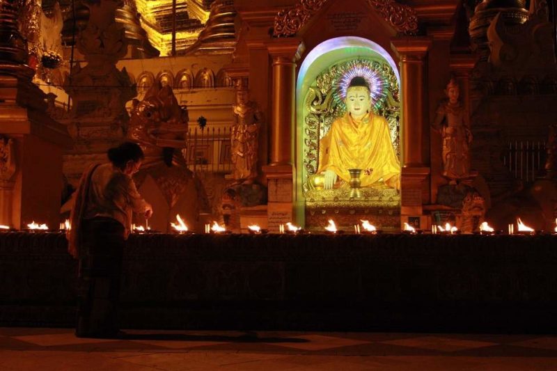 Femme allumant des bougies dans un temple bouddhiste du lac Inle -Birmanie | Au Tigre Vanillé
